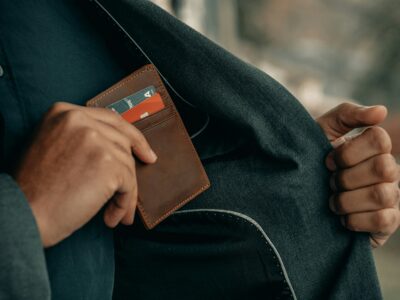 person putting wallet back in coat pocket